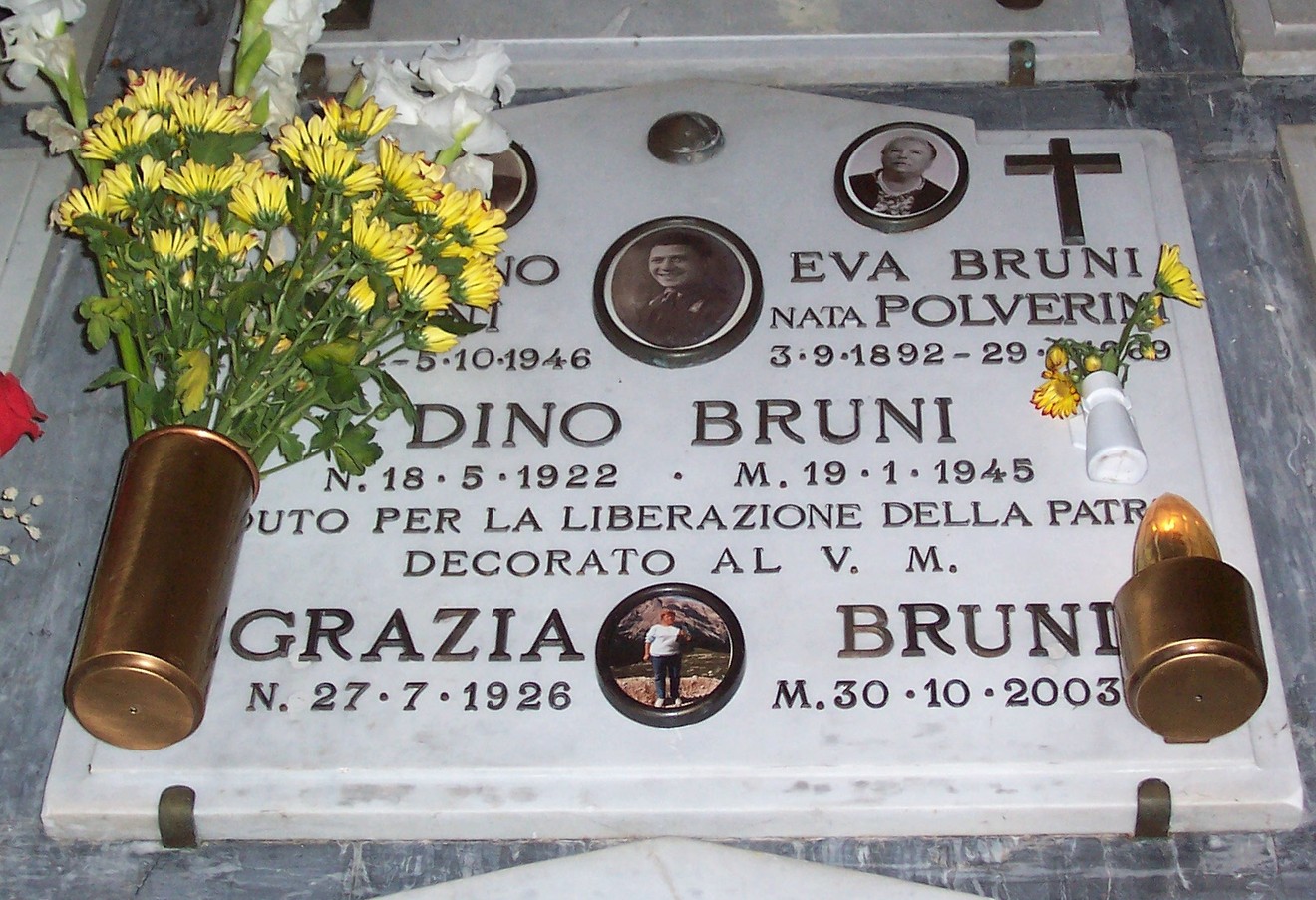 Sepolcro di famiglia Bruni, con fotografie e omaggi floreali, situato in un cimitero.