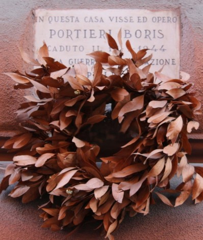 Lapide commemorativa con corona di foglie secche dedicata a Portieri Boris, caduto nella prima guerra mondiale.