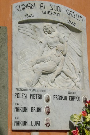 Lapide commemorativa ai caduti di Guinadi, dedicata ai valorosi membri della comunità durante la guerra.