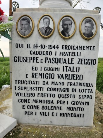 Cippo commemorativo dedicato ai fratelli Zeggio e ai cugini Varliero, situato in un campo verde.