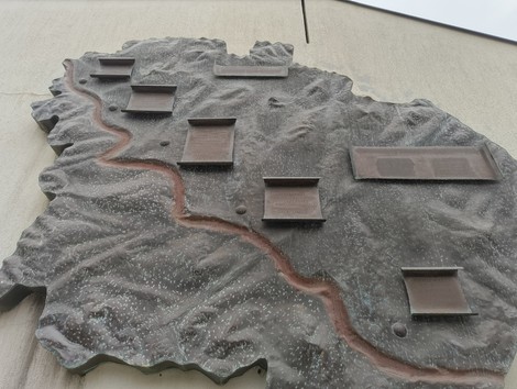 Monumento ai partigiani caduti di Pianoro, con una mappa in rilievo e placca commemorative.