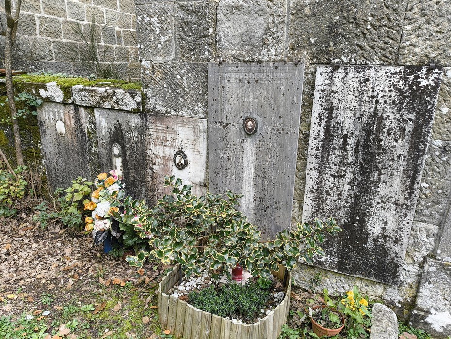 Sepolcri delle vittime di Giuncheto, con lapidi affiancate e fiori in un ambiente storico e suggestivo.