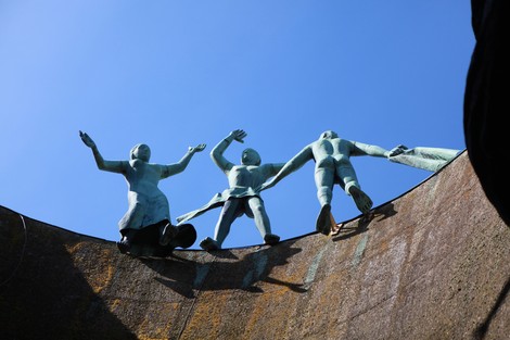 Monumento Ossario dei caduti partigiani con statue di bronzo che simboleggiano liberazione e unità.