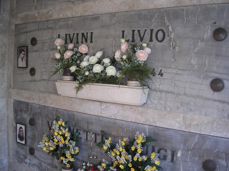 Cappella commemorativa dedicata ai partigiani, ornata di fiori e ricordi.