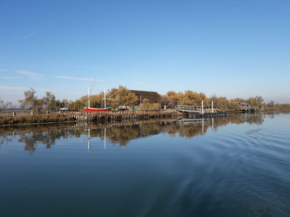 Isola degli Spinaroni: paesaggio tranquillo con acqua calma e vegetazione, riflessi nel canale.