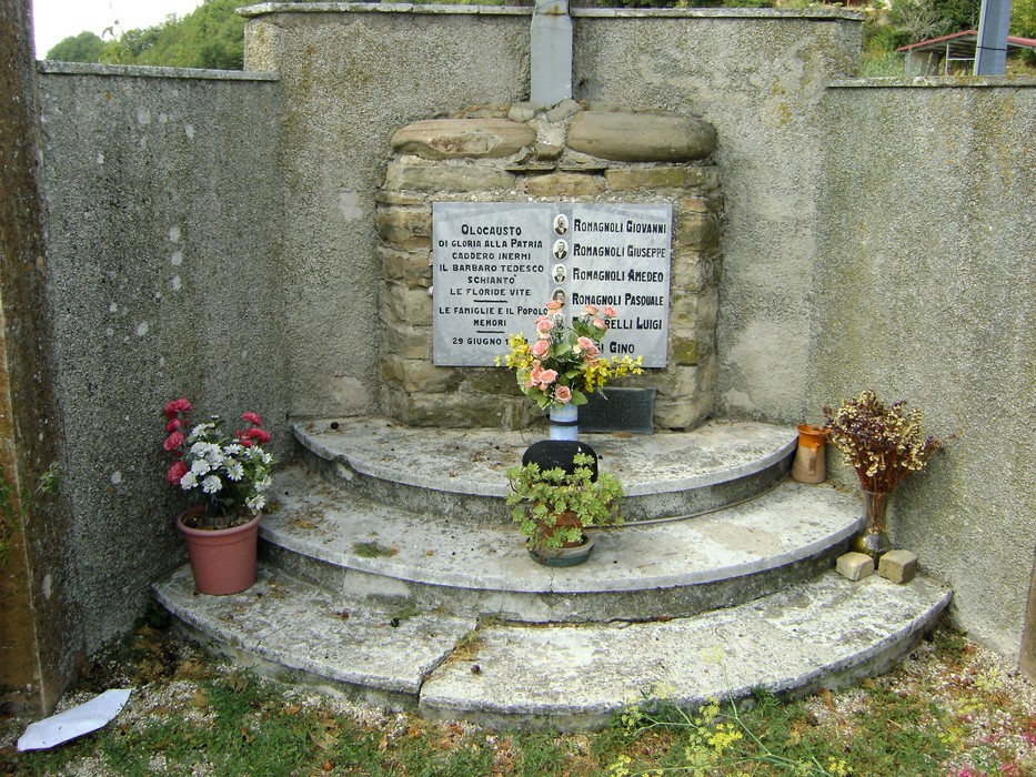 Monumento commemorativo dedicato ai caduti dell'eccidio di Montalvello, con fiori e omaggi.
