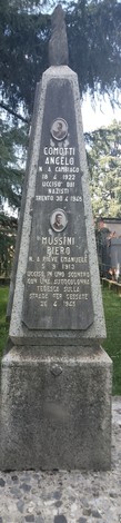 Monumento agli antifascisti con lapidi commemorative in pietra, circondato da vegetazione.