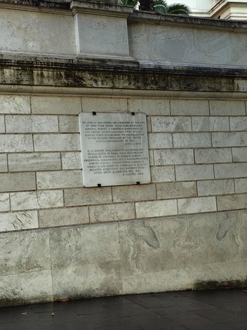Lapide commemorativa del quartier generale americano, posta su un muro di pietra in un contesto urbano.