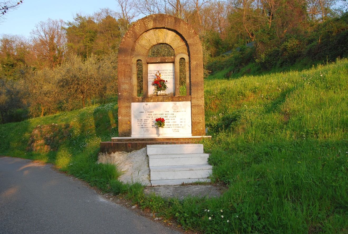 Monumento ai caduti di Caprognano, un omaggio commemorativo immerso nella natura verdeggiante.