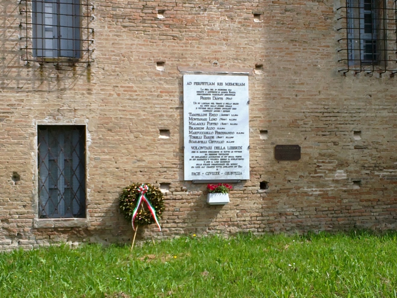 Lapide commemorativa dedicata a Freddi e ai volontari della libertà, in un contesto storico significativo.