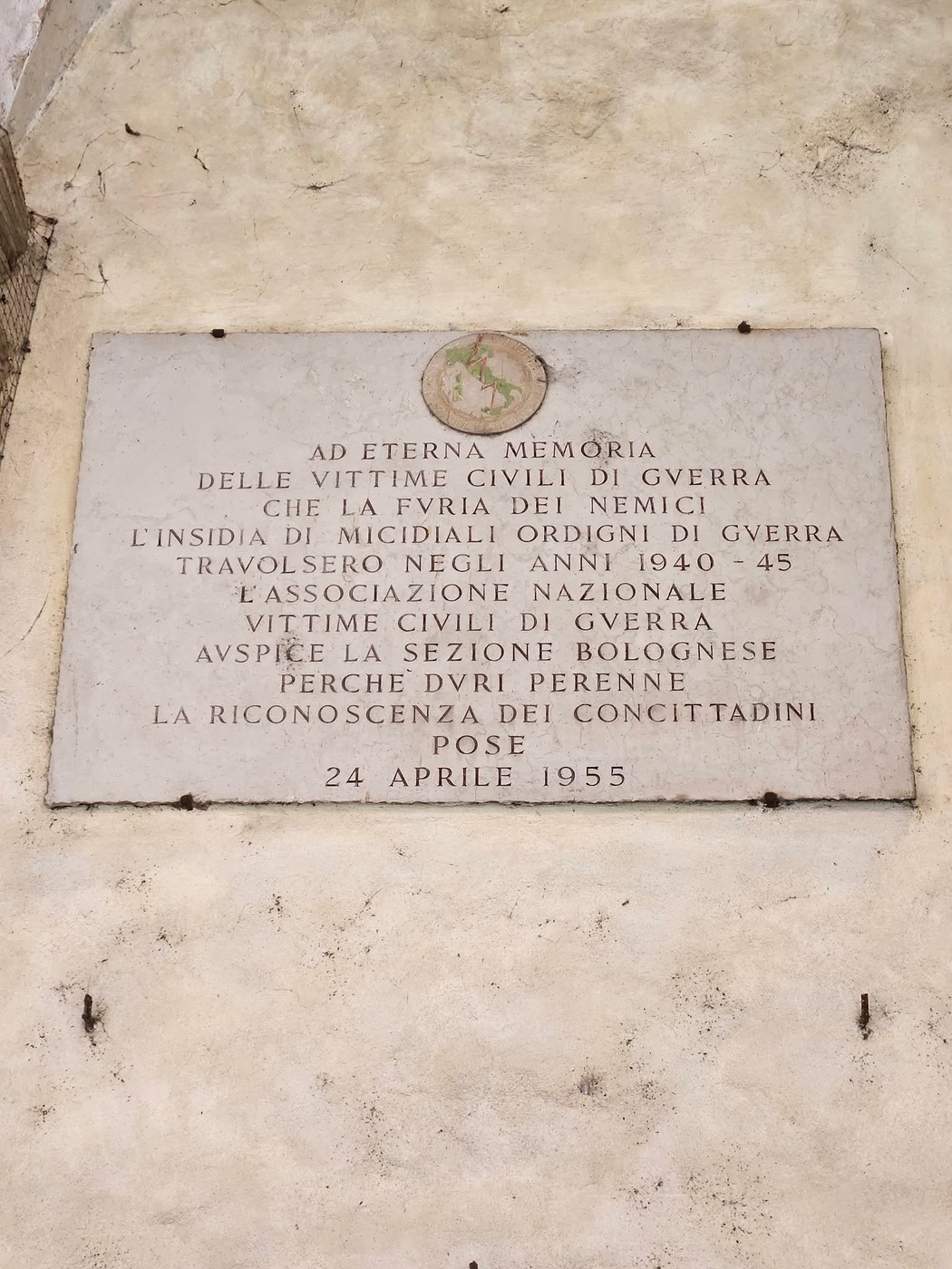 Lapide commemorativa dedicata alle vittime civili di guerra, affissa su un muro, con iscrizioni in memoria.