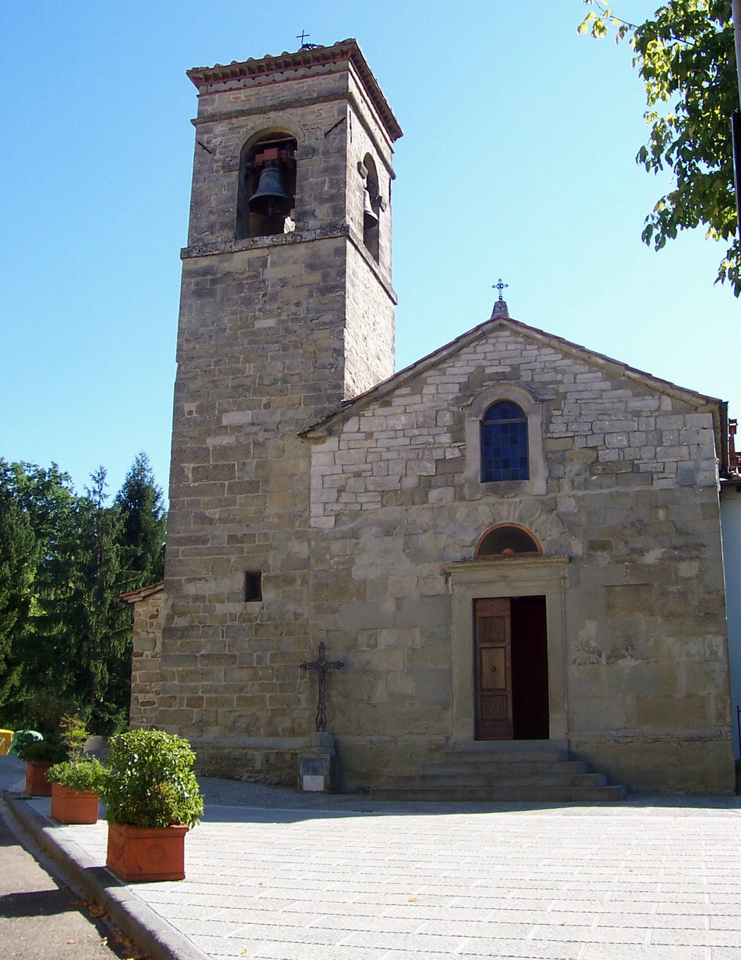 Chiesa in stile rustico con campanile, simbolo di speranza per la ricostruzione.