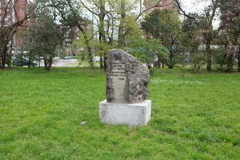 Monumento alle donne nella Resistenza, posto su una base di cemento nel verde di un parco.