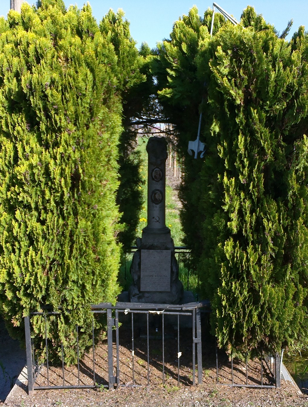 Cippo ai Saltini, monumento incastonato tra alberi, risalta in un paesaggio verde e sereno.