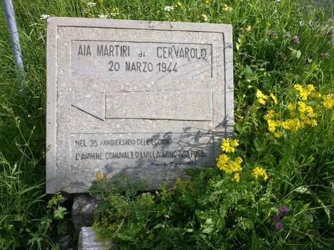 Aia di Cervarolo, luogo commemorativo con lapide dedicata ai martiri del 20 marzo 1944, circondato da fiori.