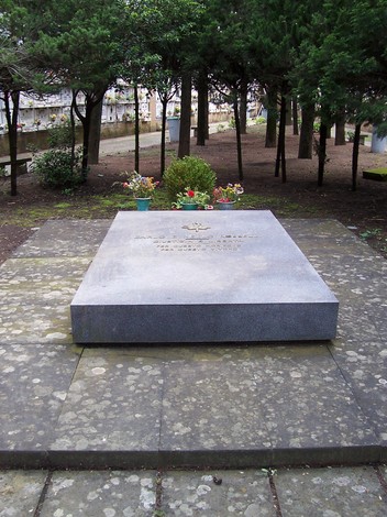 Monumento commemorativo "Il Quadrato del Non Mollare" circondato da piante e alberi in un ambiente sereno.