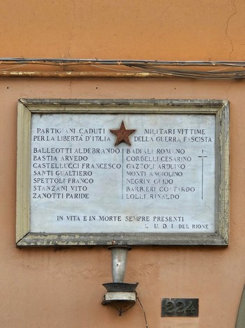 Lapide commemorativa ai caduti di Costa, dedicata a partigiani e militari della guerra, con elenco dei nomi.