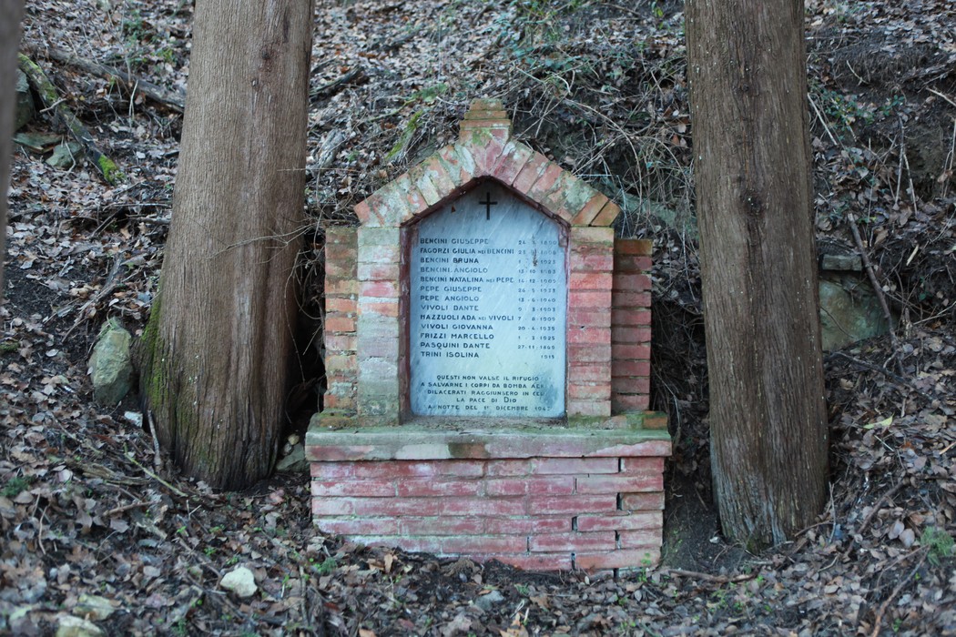 Monumento commemorativo dedicato alle vittime del bombardamento, situato tra alberi nel bosco.