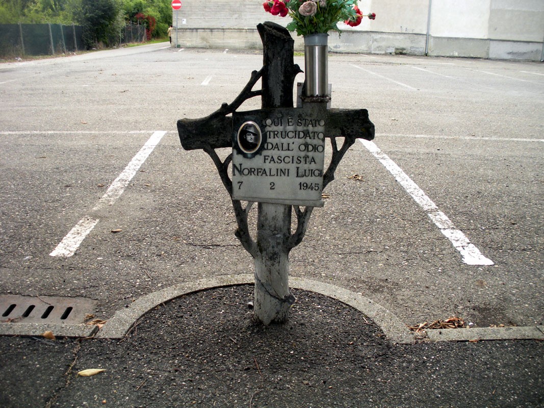 Croce commemorativa di Norfalini Luigi, vittima di ideologie fasciste, situata in un'area di sosta.