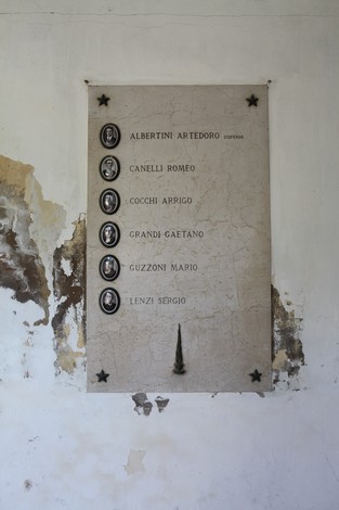 Sacrario ai Caduti Partigiani di Piumazzo, con lapide commemorativa su parete danneggiata.