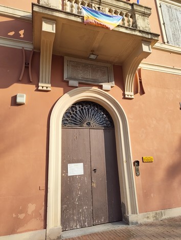 Lapide commemorativa su una facciata, dedicata ai caduti per la Libertà, con un'atmosfera di rispetto e memoria.