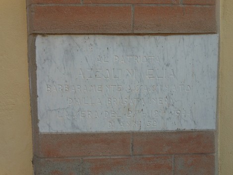 Lapide commemorativa dedicata a Azzolini, patriota vittima della brutalità. Memoria storica e onore al sacrificio.