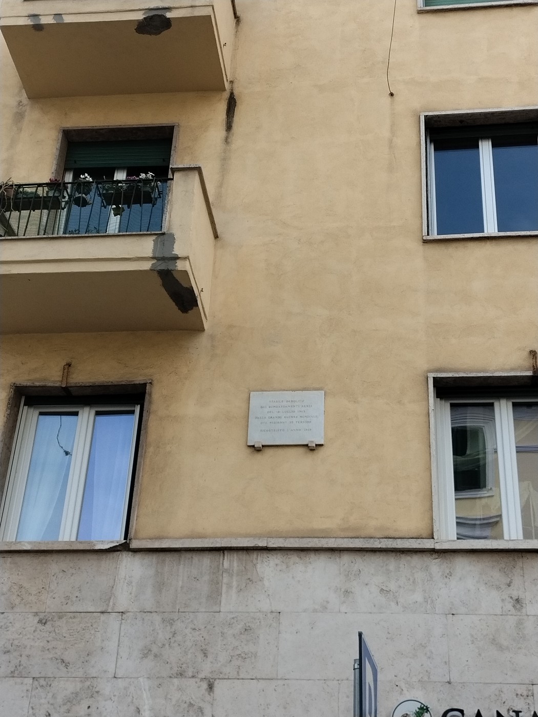 Lapide commemorativa dei caduti dei bombardamenti del 19 luglio 1943 su una facciata di edificio.