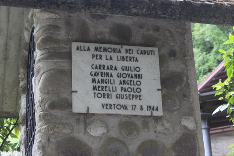 Lapide commemorativa dedicata ai caduti per la Libertà di Vertova, incastonata in una struttura di pietra.