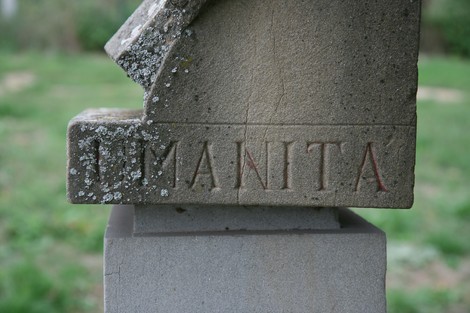 Cippo a Meuret, monumento in pietra con incisioni, immerso nella natura.