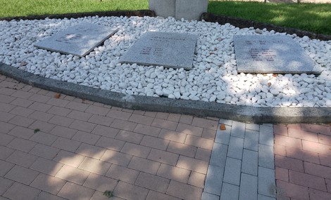 Monumento ai caduti per la Libertà, circondato da ciottoli bianchi e un'area pavimentata ben curata.
