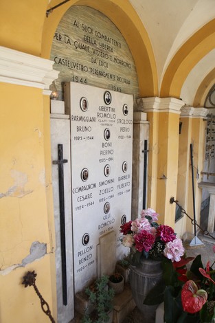Sacrario dei combattenti della libertà, con nomi e date commemorative su placche di marmo. Atmosfera di rispetto e memoria.