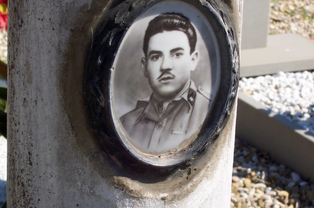 Sepolcro di Ciolli con foto commemorativa, situato in un cimitero, simbolo di memoria e rispetto.