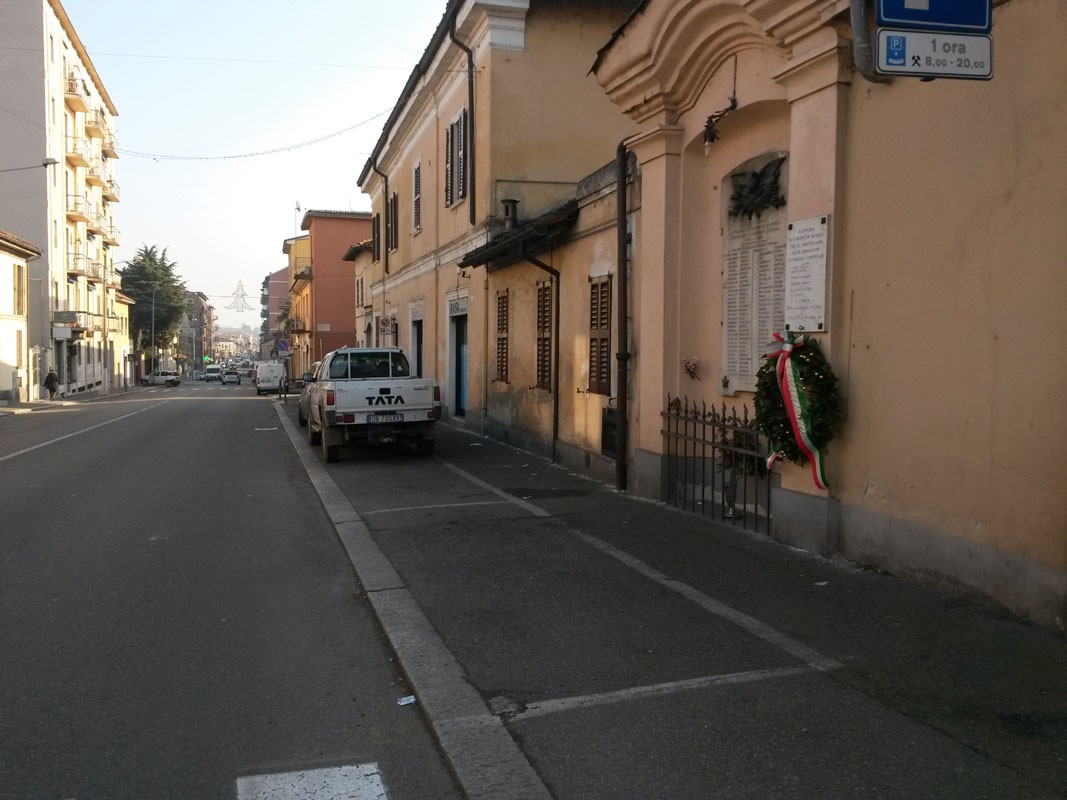 Lapide commemorativa ai caduti partigiani, situata a San Pietro in Verzolo, con corona di fiori.