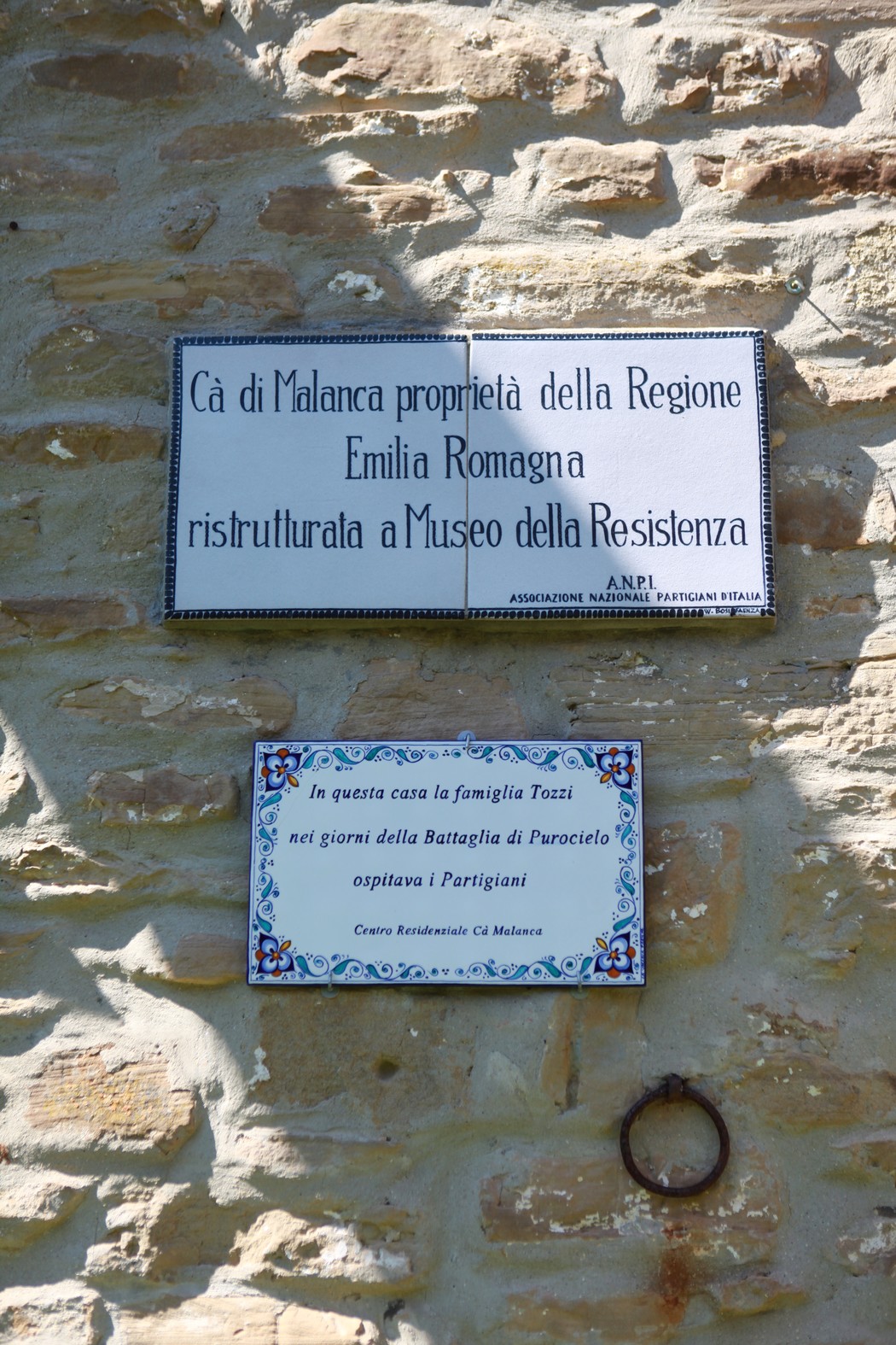 Lapide commemorativa dedicata alla famiglia Tozzi, situata in una zona storica legata alla Resistenza.