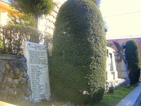 Lapide commemorativa ai caduti di Valle Mosso, immersa nel verde di un ambiente urbano.