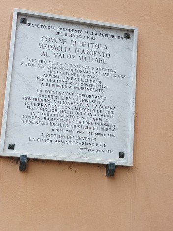 Lapide commemorativa in onore della medaglia d'argento al valor militare, con riferimenti storici e istituzionali.