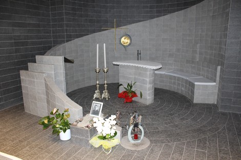 Interno della Cripta di Seghezzi, con elementi architettonici in pietra grigia e decorazioni floreali.