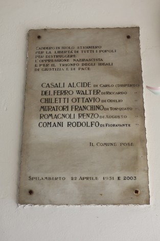 Lapide commemorativa dedicata ai partigiani italiani all'estero, con nomi e date incisi.