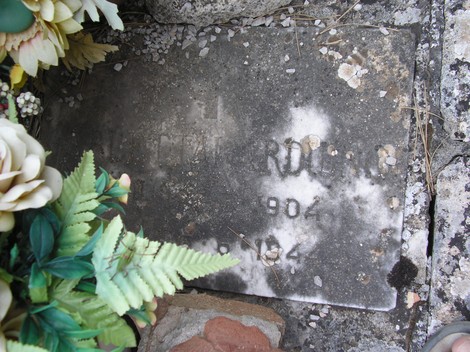 Targa commemorativa nel Sacrario dei partigiani, decorata con fiori e simboli di memoria.