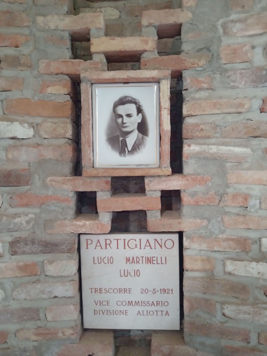 Finestra in pietra con ritratto e targa in memoria di Lucio Martinelli, partigiano di Biagasco.