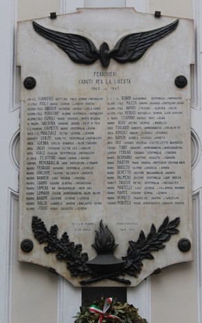 Lapide commemorativa dedicata ai ferrovieri caduti per la Libertà, con nomi e simboli di riconoscimento.