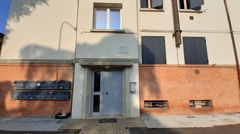 Lapide commemorativa a Gamberini e Pomoni su un edificio residenziale.