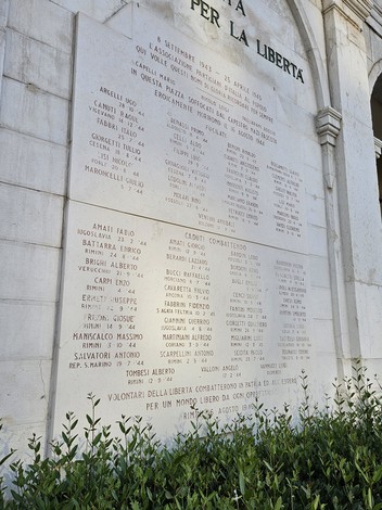 Lapide commemorativa in onore dei caduti per la libertà, con nomi incisi su una superficie di pietra.