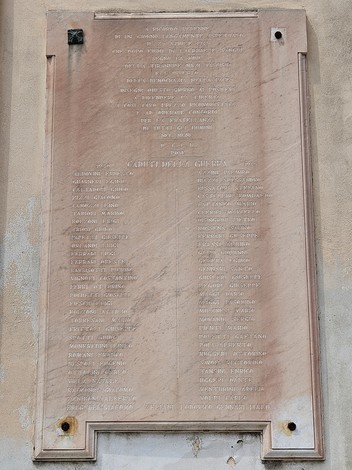 Lapide commemorativa con i nomi dei caduti della guerra 1940-1945, affissa su una superficie murale.