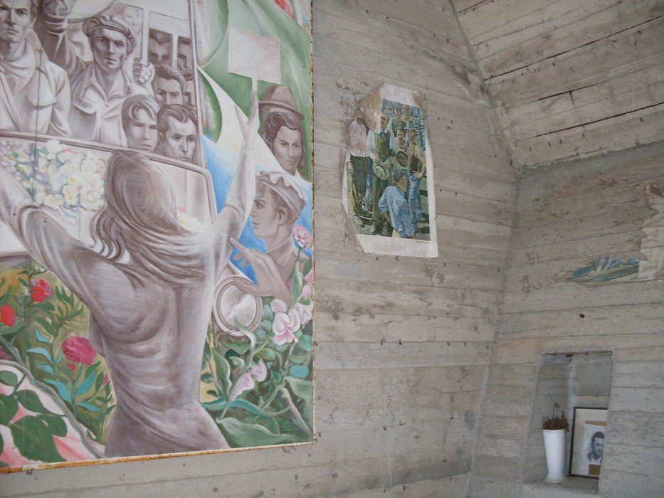 Interno del monumento ai partigiani, con murales che commemorano la lotta resistenziale e la memoria storica.