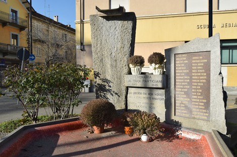 Monumento ai partigiani a Venaria, commemorazione con targhe e fiori, in un contesto urbano.