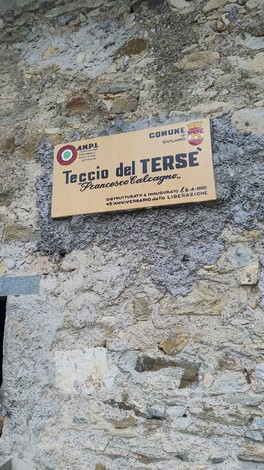 Targa del "Teccio del Terse", luogo significativo lungo il Sentiero della Memoria Partigiana, su muro in pietra.