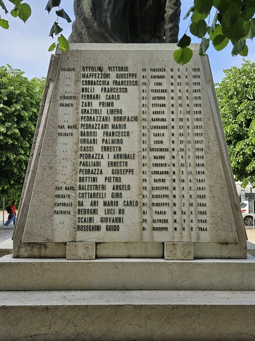 Monumento ai Caduti di Solarolo Rainerio, con inscrizioni commemorative e un alto basamento su sfondo verde.