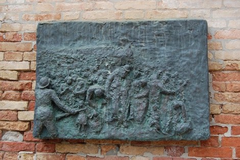 Scultura bronzea sul Monumento all'Olocausto, rappresentante scene di sofferenza e memoria storica.
