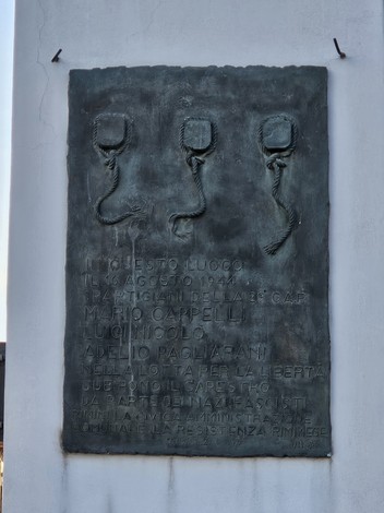 Targa commemorativa ai Tre Martiri, dedicata ai partigiani caduti nella resistenza. Design sobrio e significativo.